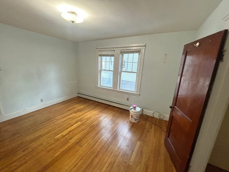 119 Bailey Road, Unit 1 Somerville, MA 02145 - Photo 9 of 25 an empty room with wooden floor and windows