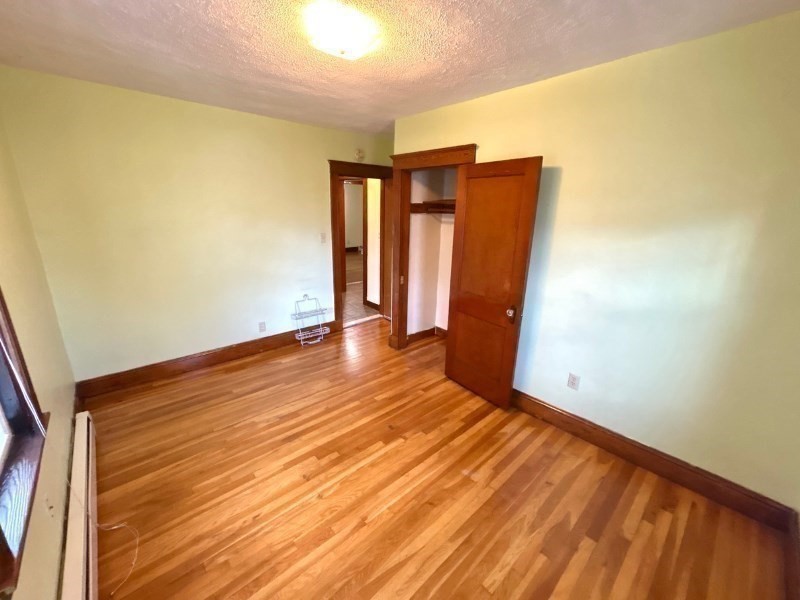 119 Bailey Road, Unit 1 Somerville, MA 02145 - Photo 10 of 25 a view of an empty room with wooden floor and a window