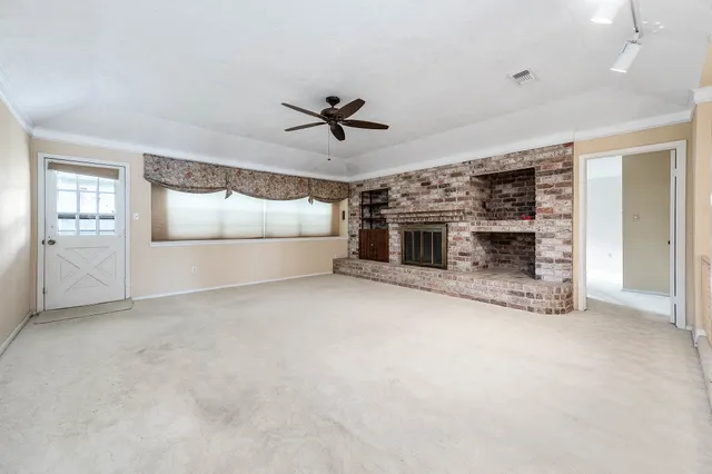 an empty room with windows and fireplace