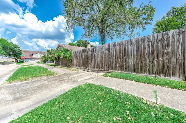 a view of a backyard with wooden fence