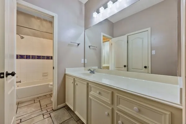 a bathroom with a sink and a mirror with bathtub