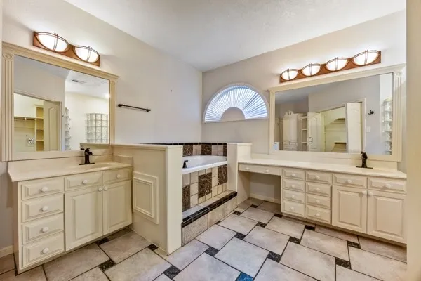 a spacious bathroom with a double vanity sink mirror and bathtub