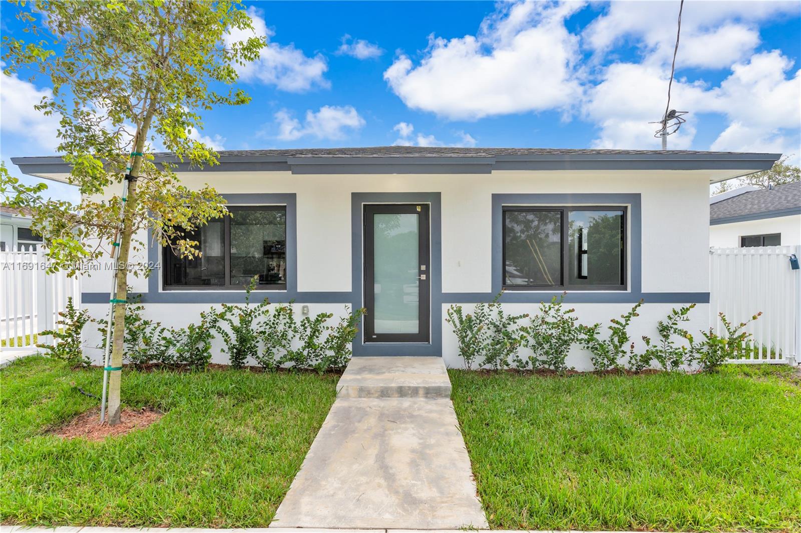 11970 Southwest 213th Street, Unit 1 Miami, FL 33177 - Photo 3 of 36 a front view of a house with a garden