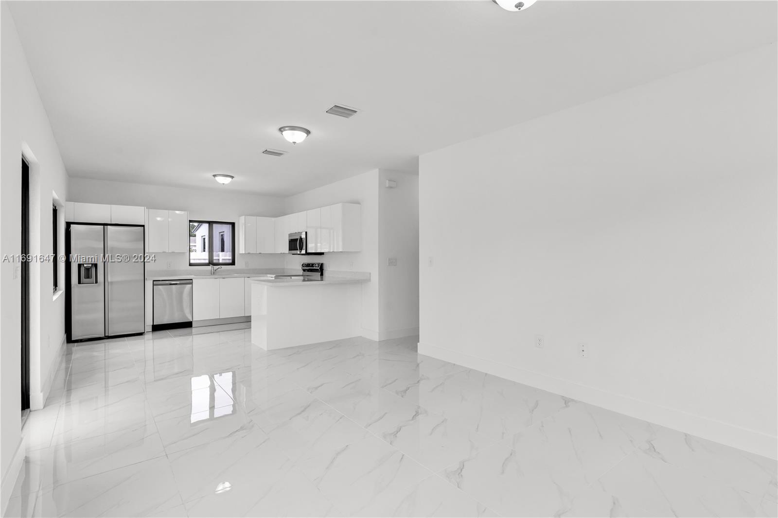 11970 Southwest 213th Street, Unit 1 Miami, FL 33177 - Photo 6 of 36 a view of a kitchen with refrigerator and windows