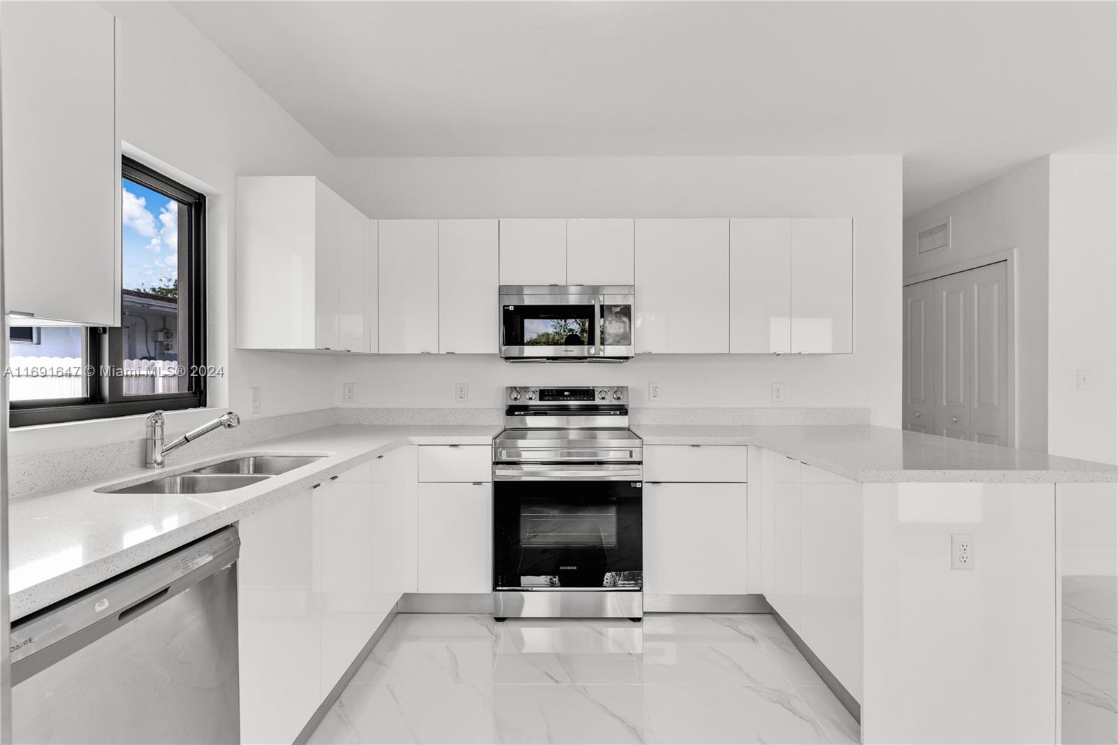 11970 Southwest 213th Street, Unit 1 Miami, FL 33177 - Photo 10 of 36 a kitchen with a sink cabinets and stainless steel appliances