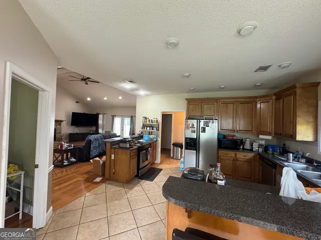 a kitchen with a refrigerator and a stove top oven