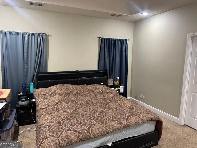 a bed sitting in a bedroom next to a window