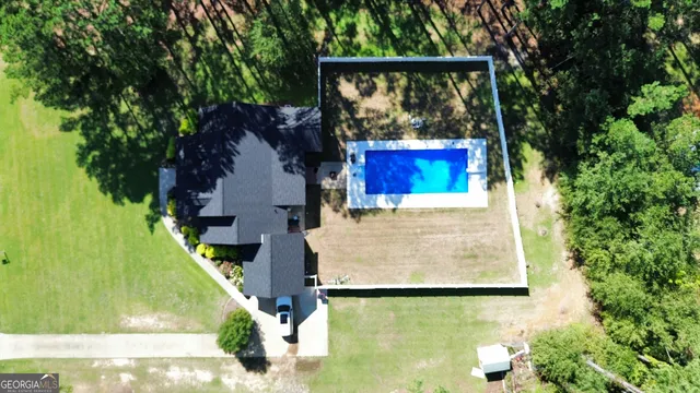 swimming pool view with a garden and outdoor seating