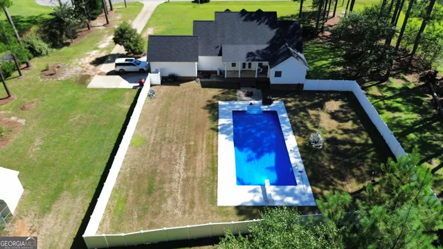 an aerial view of a house with swimming pool outdoor seating and yard