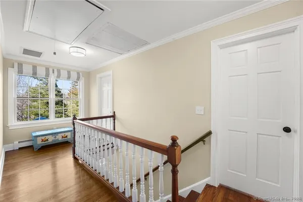 a view of a hallway with a large window and wooden floor