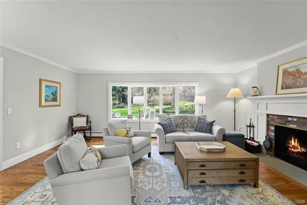 a living room with furniture large window and a fireplace