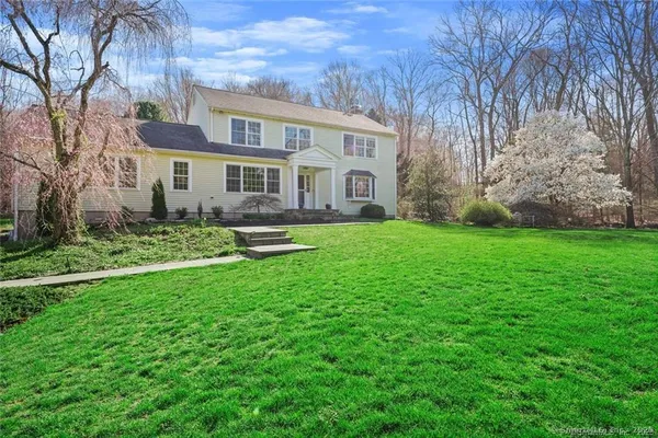 a front view of house with yard and green space
