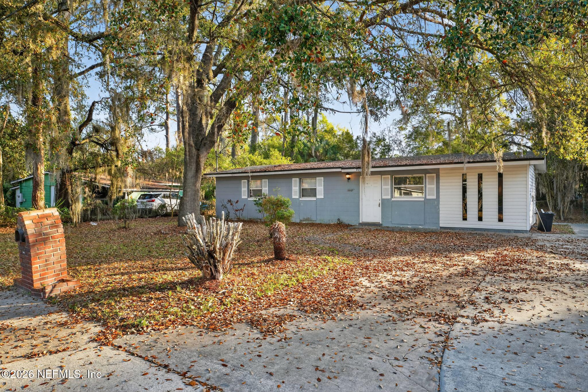 a view of a house with backyard and tree