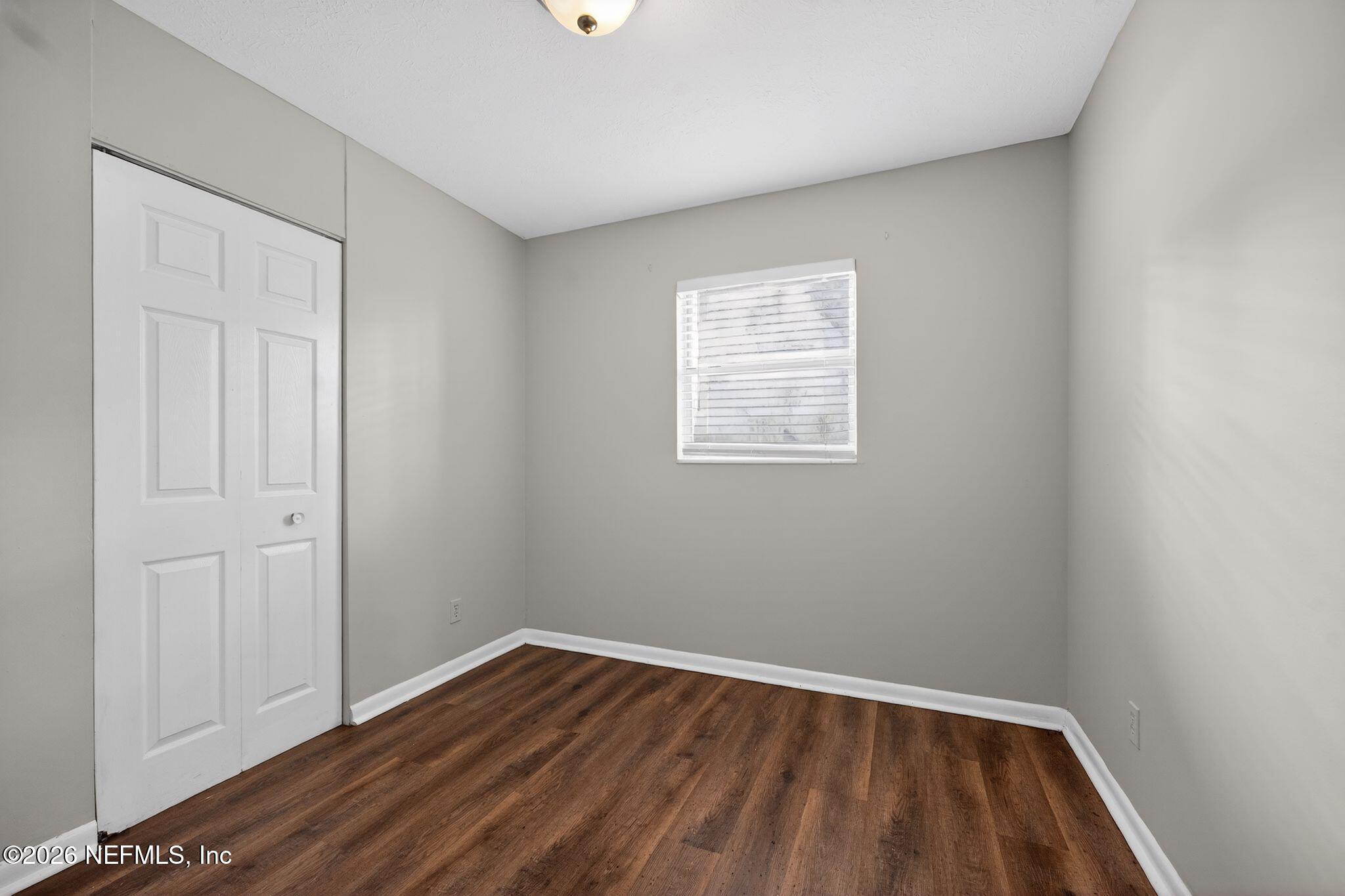 8609 Oak Leaf Road Jacksonville, FL 32208 - Photo 12 of 18 an empty room with wooden floor and windows