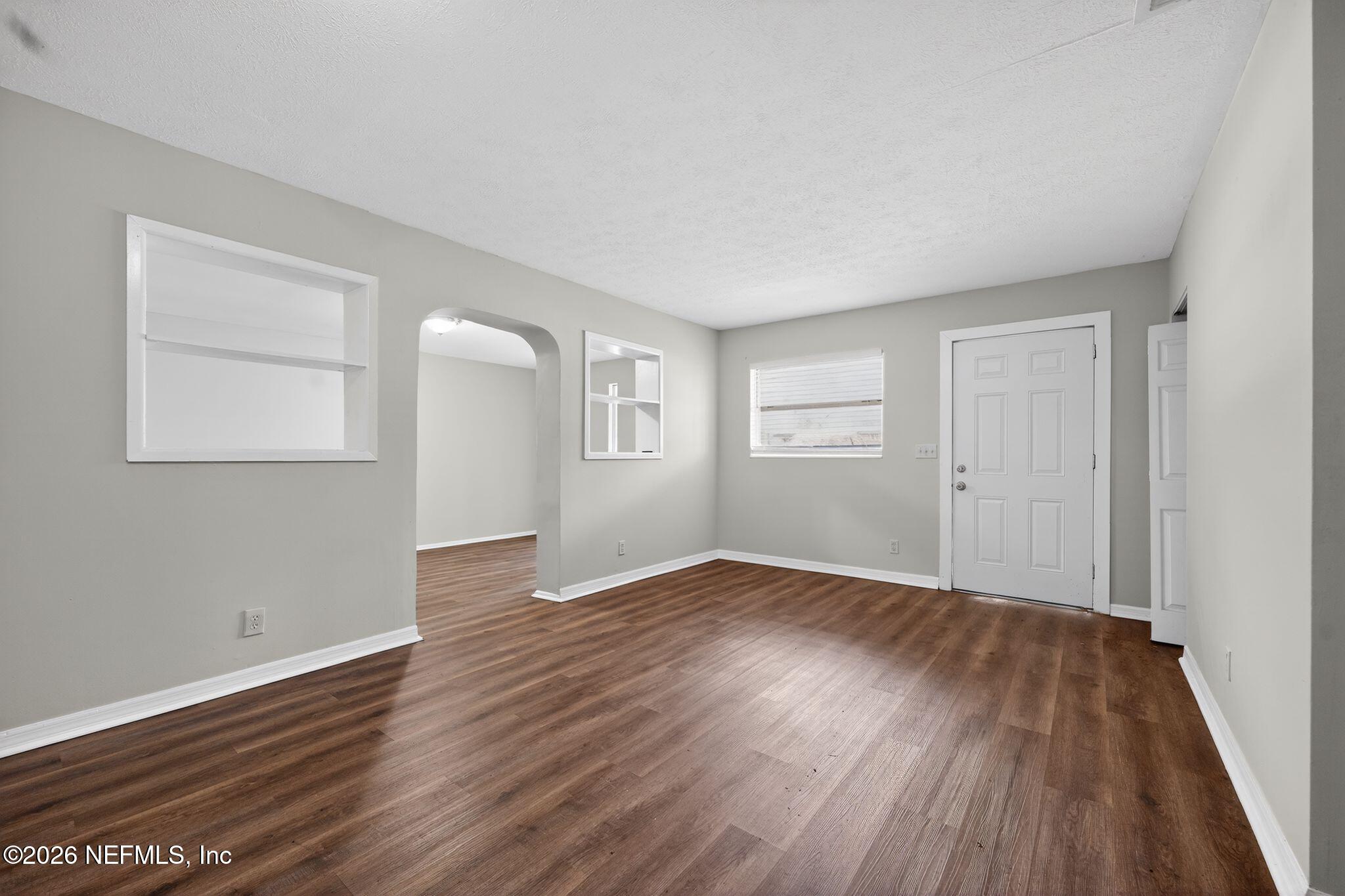 8609 Oak Leaf Road Jacksonville, FL 32208 - Photo 6 of 18 an empty room with wooden floor and windows