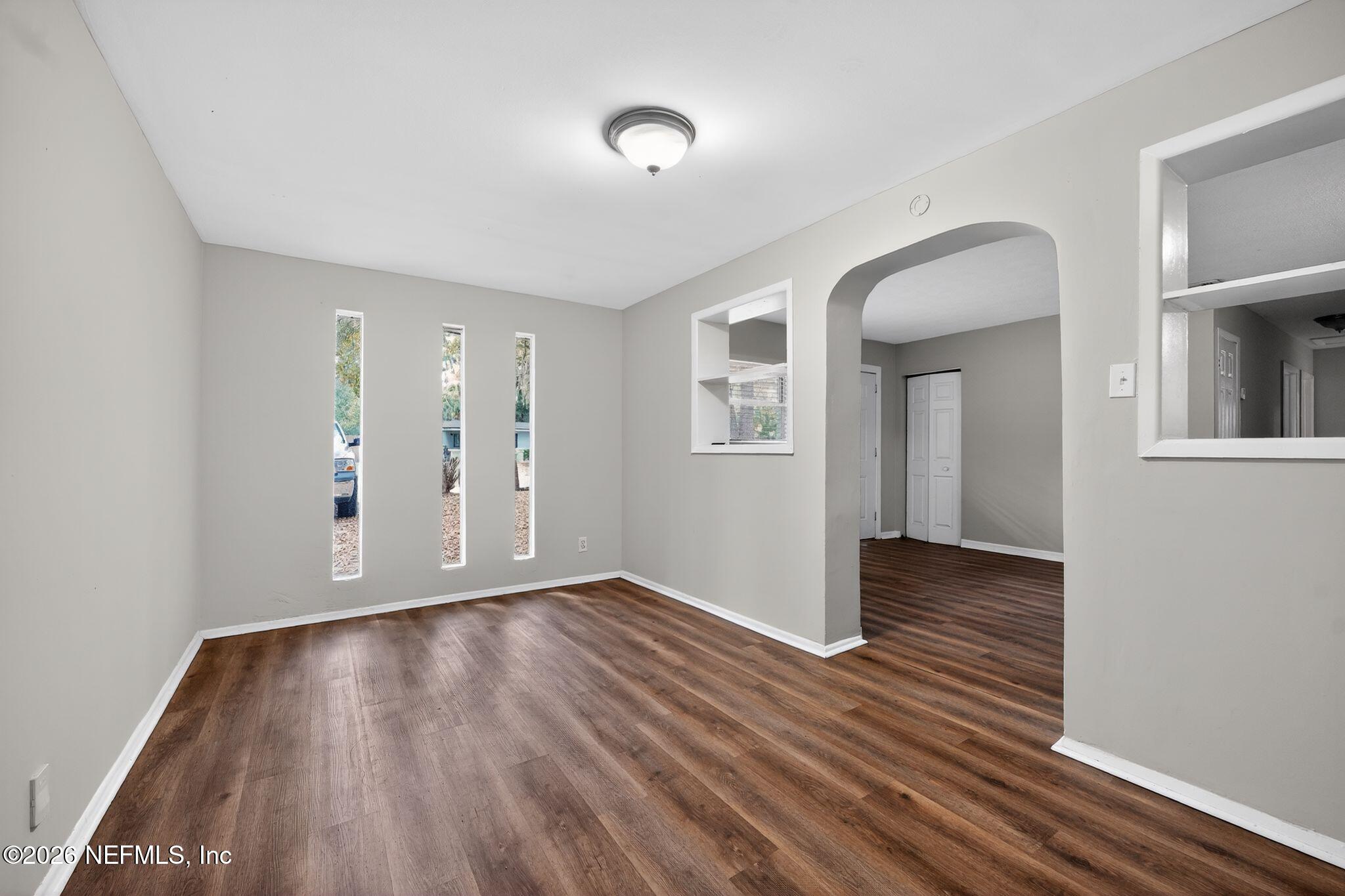 8609 Oak Leaf Road Jacksonville, FL 32208 - Photo 7 of 18 a view of an empty room with wooden floor and a window