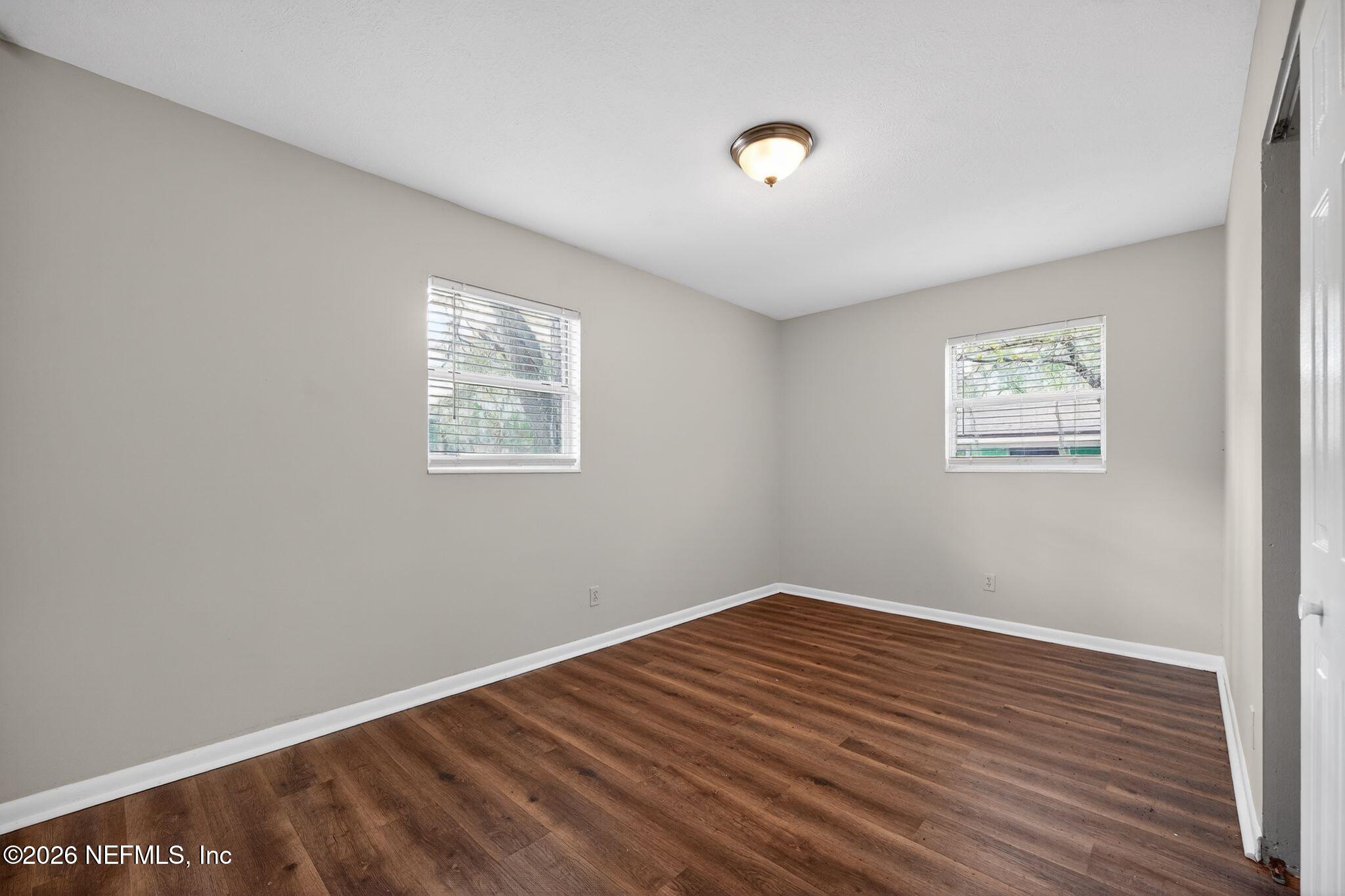8609 Oak Leaf Road Jacksonville, FL 32208 - Photo 10 of 18 an empty room with wooden floor and windows