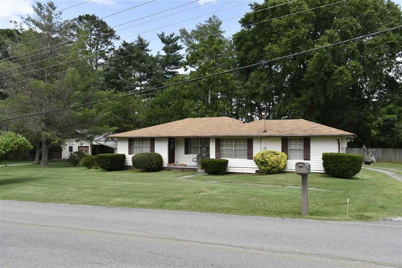 a view of a house with a yard and large trees