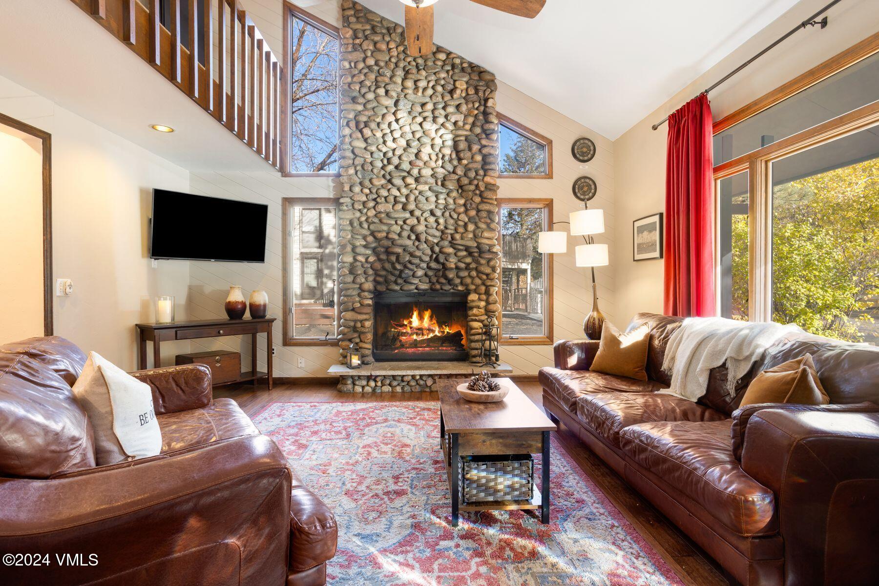 a living room with furniture a flat screen tv and a fireplace