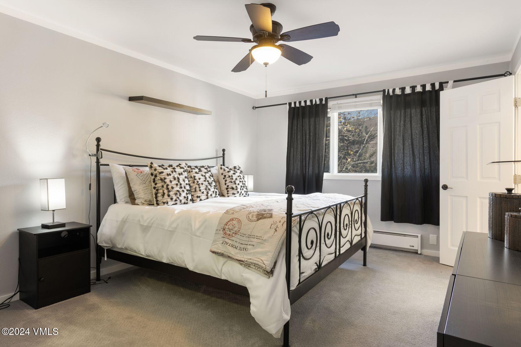 149 Deer Boulevard, Unit A Eagle-Vail, CO 81620 - Photo 15 of 22 a bedroom with a bed and a chandelier
