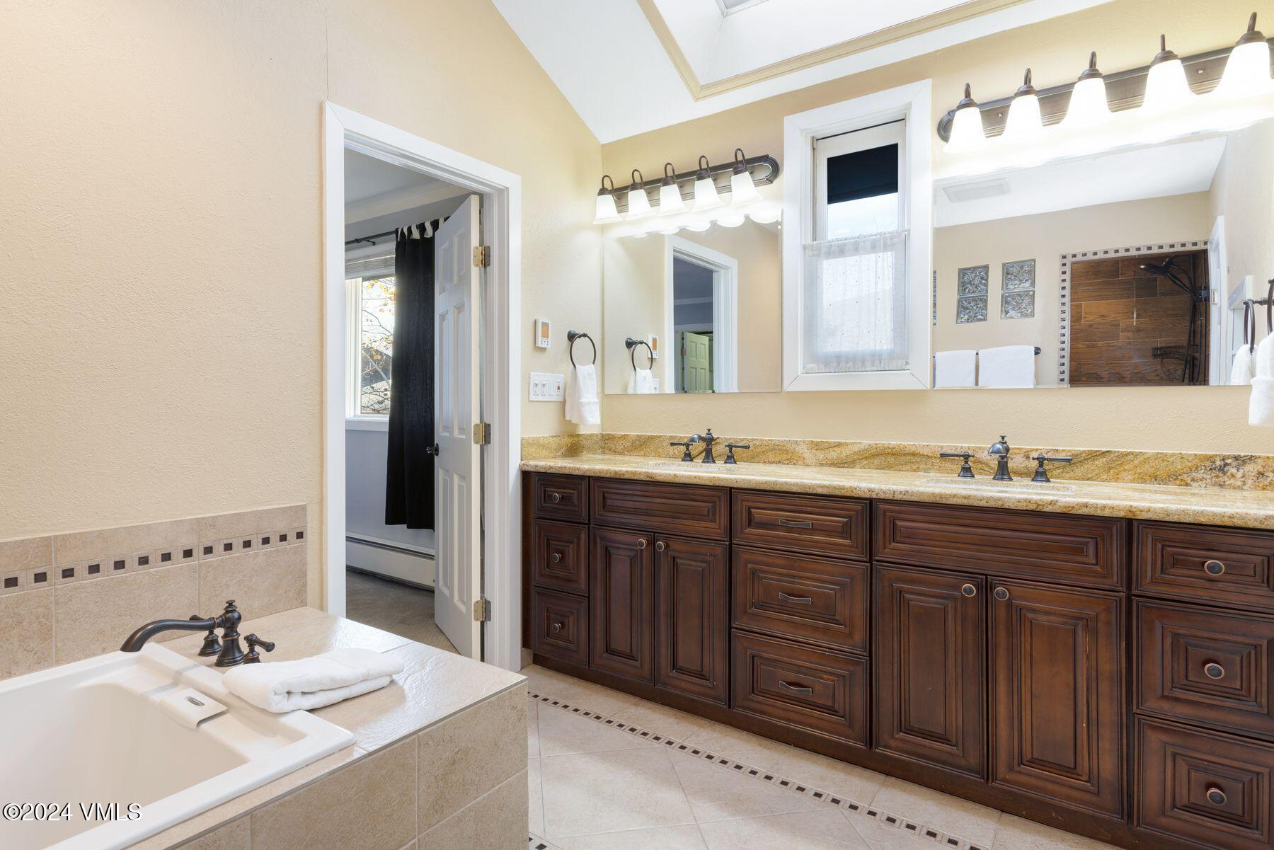 149 Deer Boulevard, Unit A Eagle-Vail, CO 81620 - Photo 18 of 22 a bathroom with a tub sink and mirror