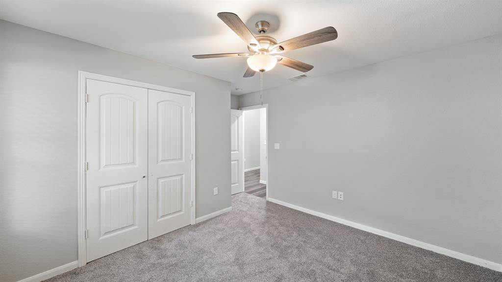 207 East McCoulskey Street Terrell, TX 75160 - Photo 14 of 29 an empty room with a chandelier fan and closet