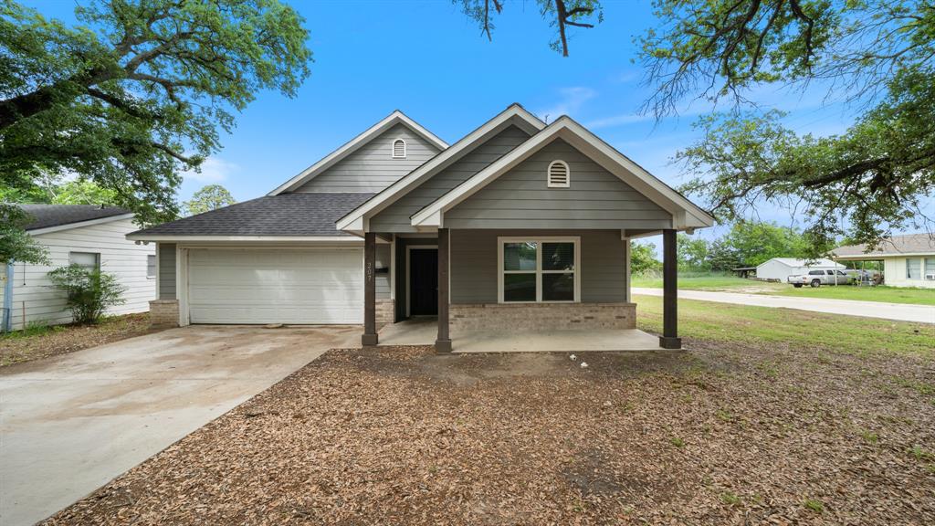 207 East McCoulskey Street Terrell, TX 75160 - Photo 26 of 29 a front view of a house with a yard and garage