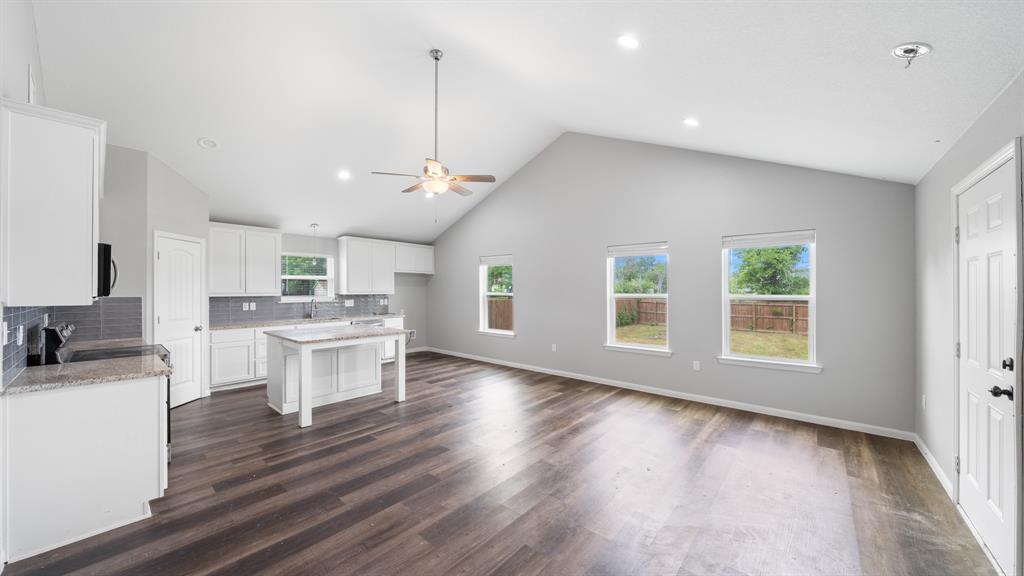 207 East McCoulskey Street Terrell, TX 75160 - Photo 4 of 29 a open kitchen with a sink dishwasher a dining table and chairs with wooden floor