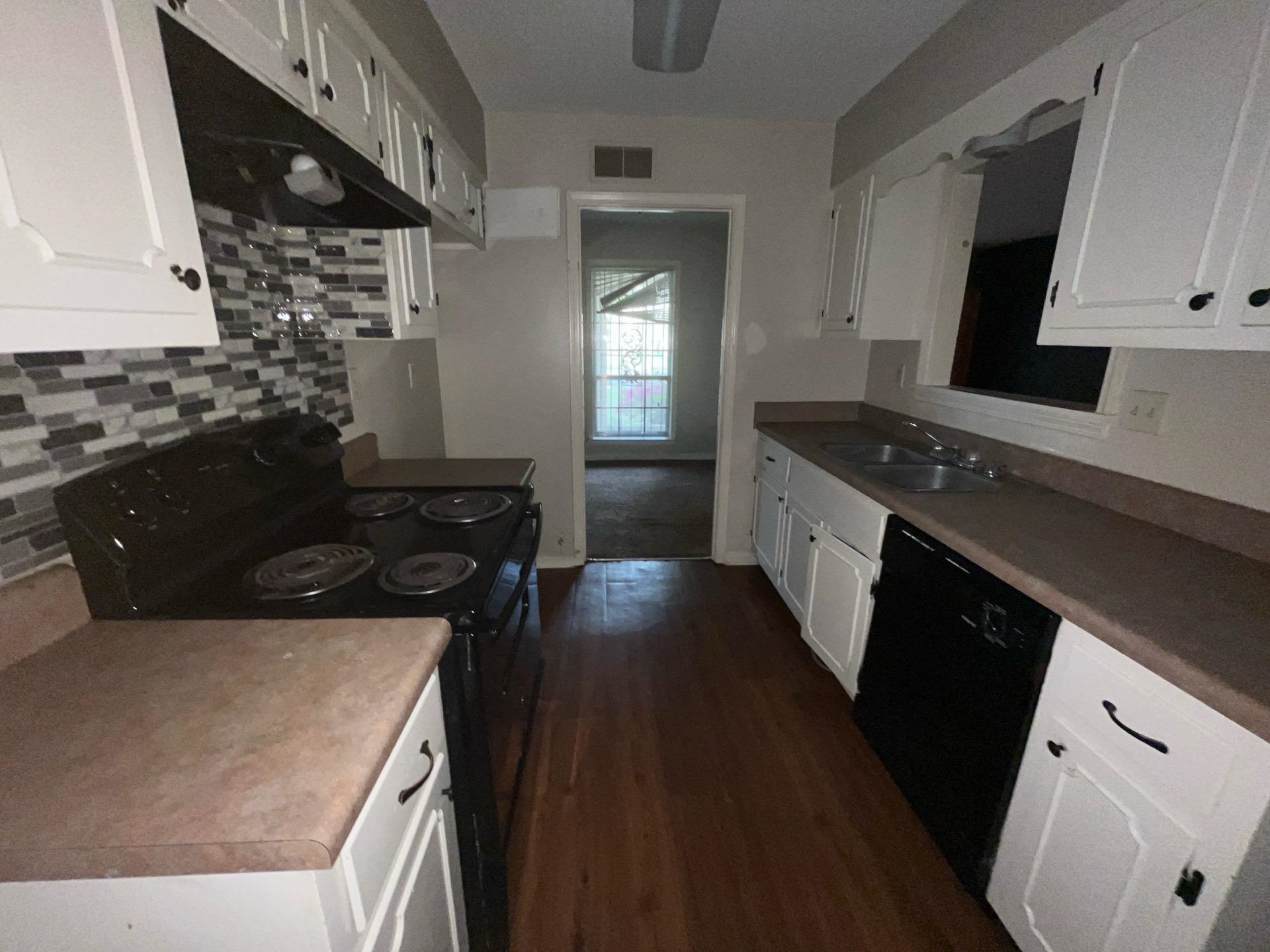 4149 Meadow Creek Road Memphis, TN 38115 - Photo 4 of 13 Kitchen featuring tasteful backsplash, visible vents, black appliances, under cabinet range hood, and a sink