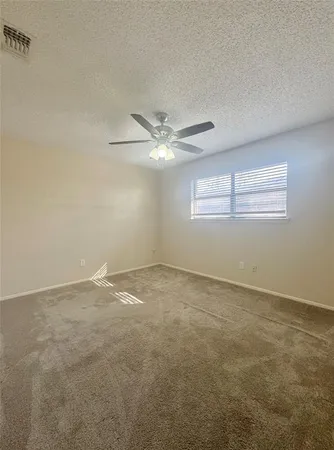 a view of an empty room with a ceiling fan