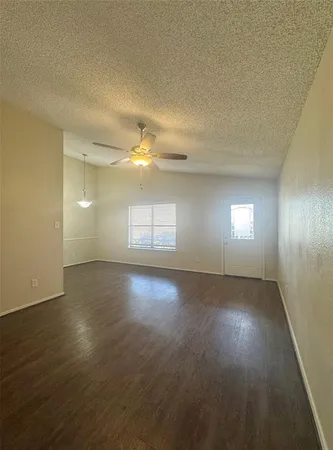 a view of a kitchen with wooden floor and a ceiling fan