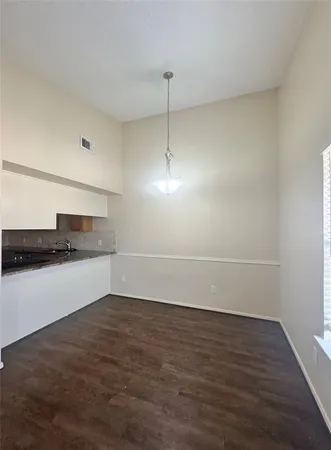 a kitchen with granite countertop a sink cabinets and stainless steel appliances