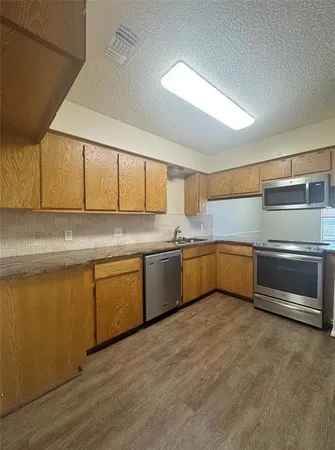 a kitchen with granite countertop a sink and cabinets