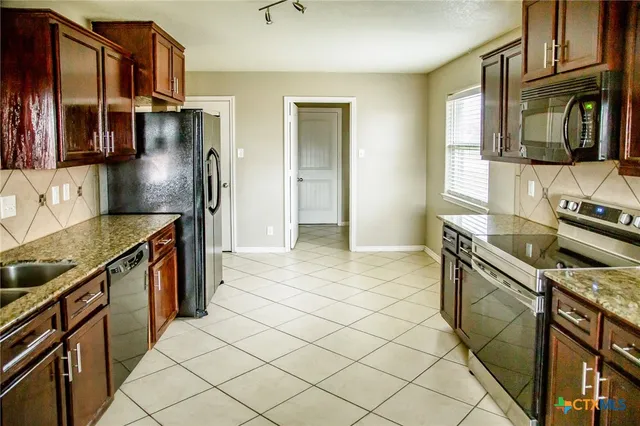 a kitchen with stainless steel appliances granite countertop a sink and a stove top oven