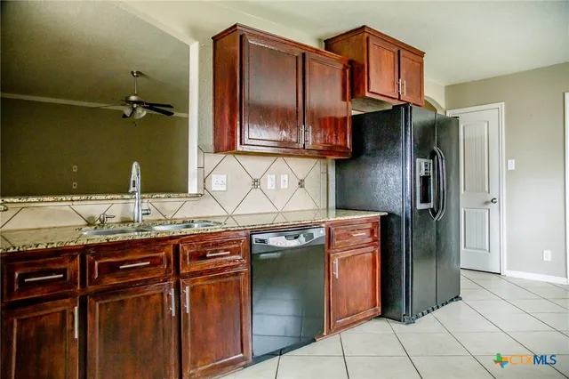 a kitchen with stainless steel appliances granite countertop a sink and a refrigerator