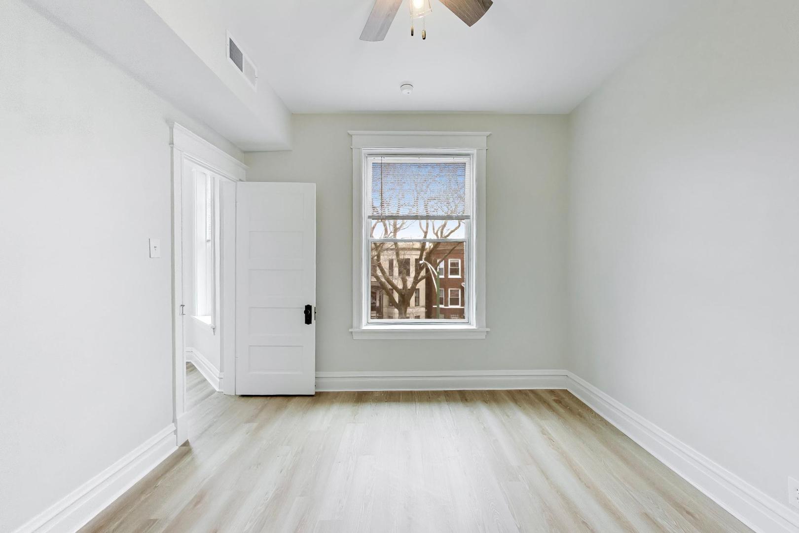 1646 West Byron Street, Unit 2F Chicago, IL 60613 - Photo 20 of 27 an empty room with wooden floor and windows