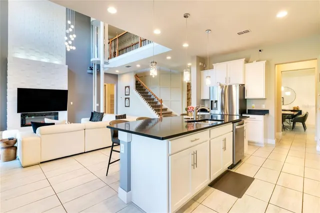 a living room with stainless steel appliances kitchen island granite countertop a sink and cabinets
