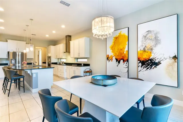 a kitchen with stainless steel appliances a dining table and chairs