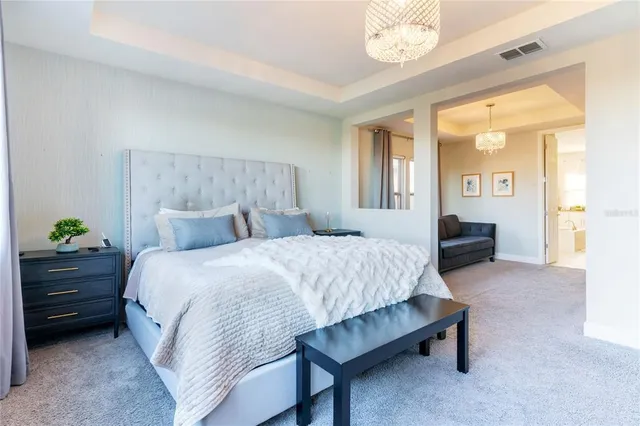 a spacious bedroom with a bed table and a window