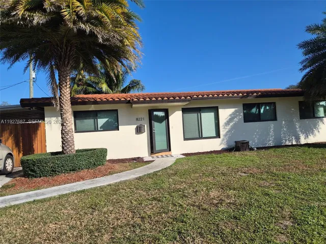 a front view of a house with a garden and yard