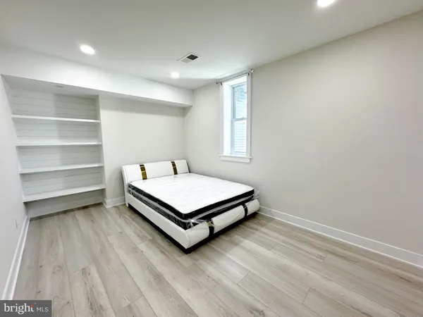 a spacious bedroom with a bed and a window