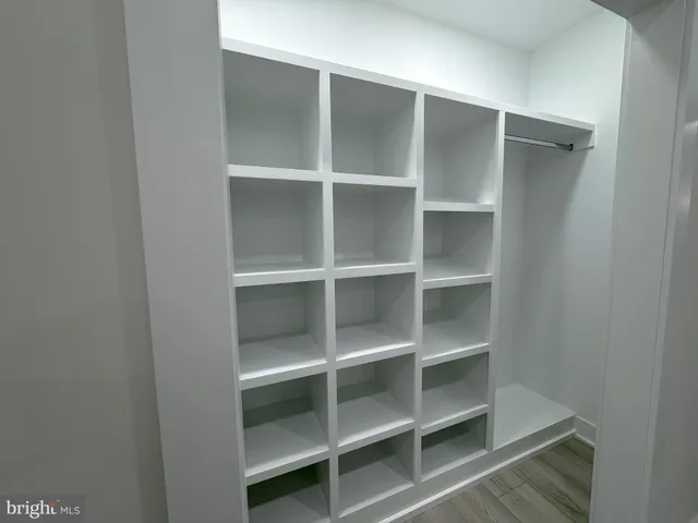 a view of walk in closet with empty racks