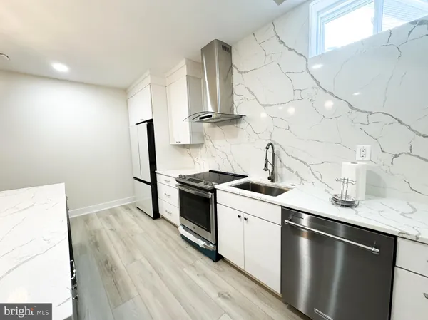 a kitchen with stainless steel appliances a sink stove and cabinets