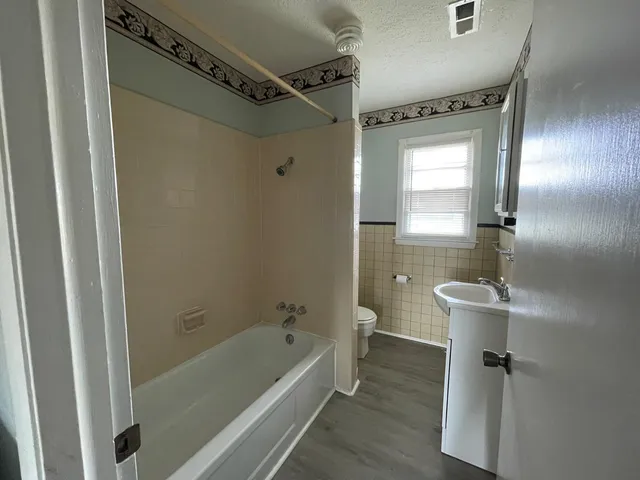 a bathroom with a tub a sink and mirror