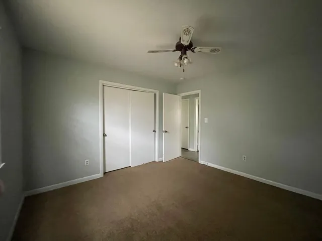 a view of a big room with a chandelier fan and windows