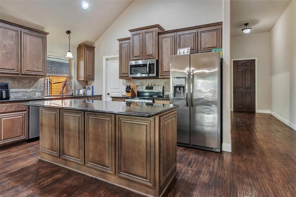 629 Fox View Drive Fort Worth, TX 76131 - Photo 9 of 38 a kitchen with stainless steel appliances granite countertop a refrigerator a sink dishwasher and wooden cabinets with wooden floor