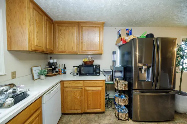 a kitchen with a refrigerator and a stove top oven