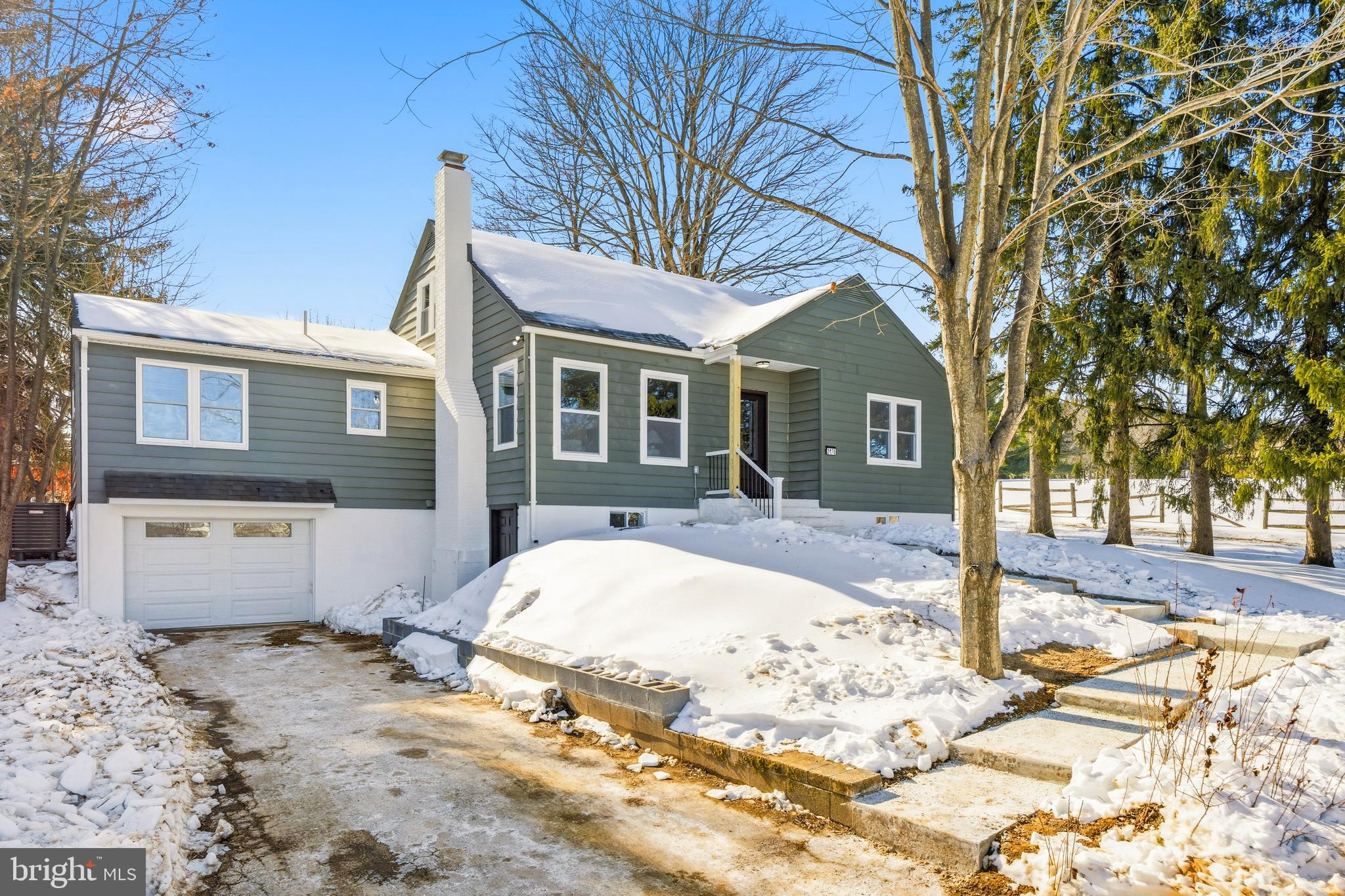 a view of a white house with a large tree