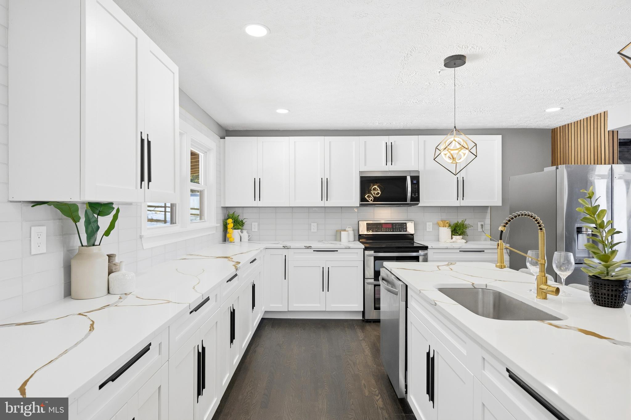 3170 Sykesville Road Westminster, MD 21157 - Photo 12 of 37 a kitchen with stainless steel appliances a sink a stove a microwave a sink a refrigerator white cabinets and wooden floor
