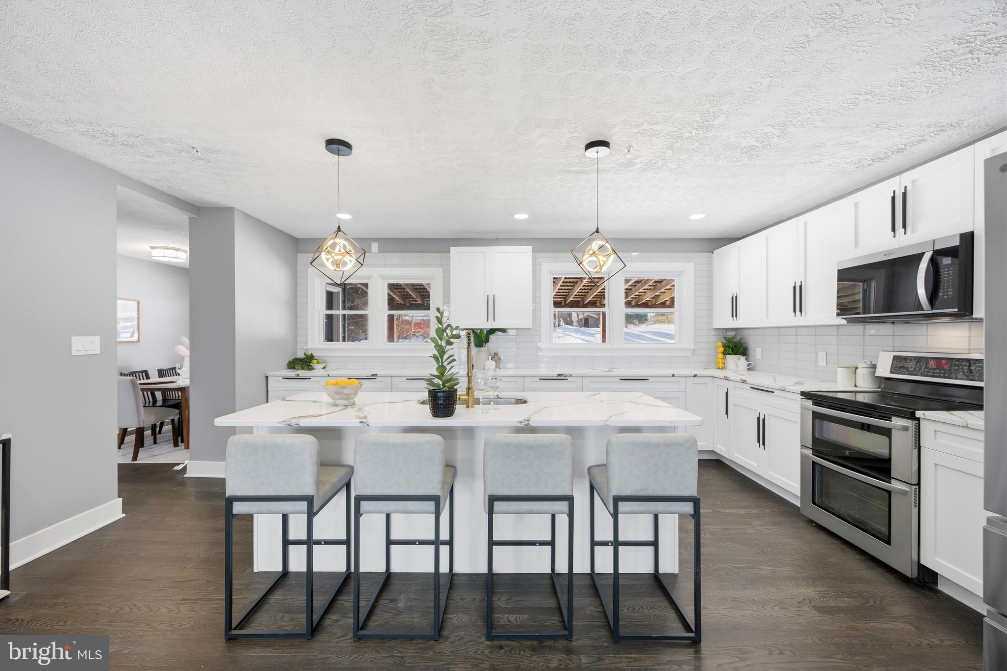 3170 Sykesville Road Westminster, MD 21157 - Photo 10 of 37 a kitchen with stainless steel appliances granite countertop a stove top oven a sink dishwasher a dining table and chairs with wooden floor